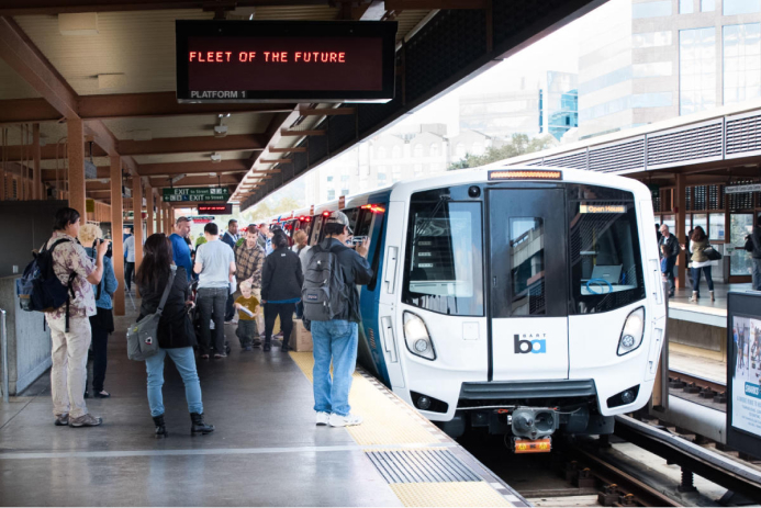 A new BART train stopped at a crowded platform